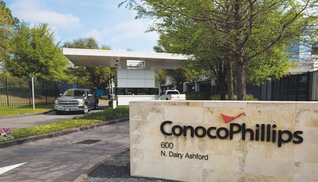Cars exit ConocoPhillips headquarters in Houston, Texas. US oil and gas producers ConocoPhillips and Chevron have published plans to slash their 2016 budgets by a quarter.