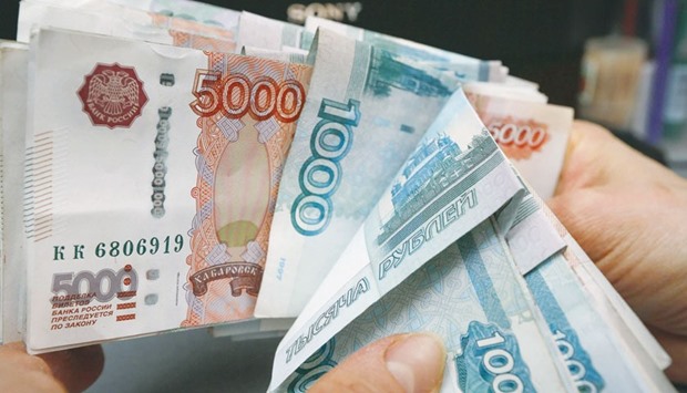 An employee counts rouble banknotes at a shop in Krasnoyarsk, Russia. The rouble is the worldu2019s third-worst performer in December with an 8% loss against the dollar.