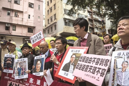 Protesters hold up missing person notices of  Mighty Current publisher of books critical of China companyu2019s general manager Lui Bo and colleagues Cheung Jiping, Gui Minhai, Lee Bo and Lam Wing-kei as they walk towards Chinau2019s Liaison Office in Hong Kong yesterday.