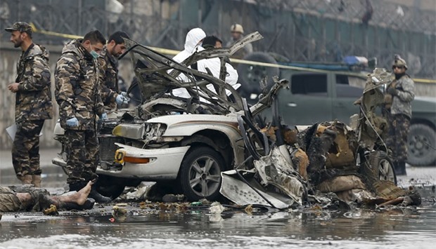 Afghan security forces investigate the wreckage of a vehicle used by suicide attack in Kabul, Afghanistan January 4, 2016.  A suicide bomber in a car blew himself up close to a police checkpoint near Kabul airport on Monday but caused no other casualties, a police spokesman said. REUTERS