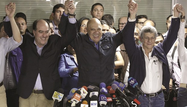 Jesus Torrealba (centre) , secretary of Venezuelau2019s coalition of opposition parties (MUD), holds hands with MUD deputy Henry Ramos Allup (right) and fellow deputy Julio Borges during a news conference in Caracas.