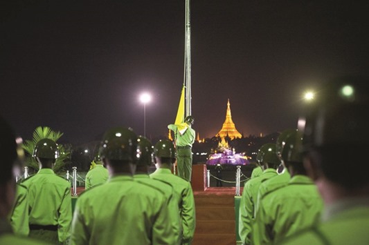 Guards of honour stand at attention during a flag-raising ceremony to mark Myanmaru2019s 68th Independence Day at the Peopleu2019s Square near Shwedagon Pagoda in Yangon early yesterday.