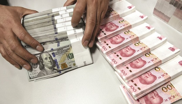 A clerk counts Chinese yuan and US dollar banknotes at a branch of Bank of China in Taiyuan, Shanxi province. The Chinese currency softened against the dollar yesterday to its weakest level since April 2011.