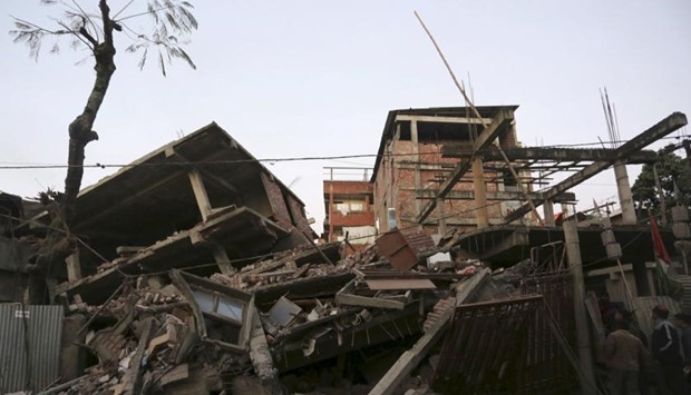 People look at damaged houses after an earthquake in Imphal on Monday.