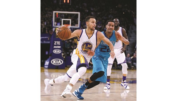 Stephen Curry of the Golden State Warriors dribbles past Brian Roberts of the Charlotte Hornets during their NBA game in Oakland on Monday.