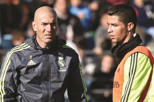 Real Madridu2019s new coach Zinedine Zidane (left) walks past forward Cristiano Ronaldo during his first training session.