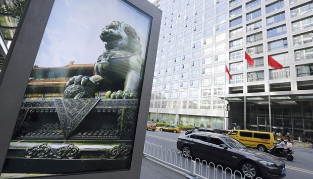 An advertising board (left) showing a Chinese stone lion is pictured near an entrance to the headquarters (right) of China Securities Regulatory Commission in Beijing. The CSRC signalled itu2019s open to tweaking the countryu2019s new market circuit breakers after analysts blamed the rules for exacerbating a $590bn rout in stocks on Monday.