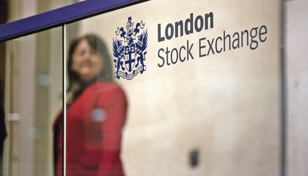 A visitor passes a sign inside the London Stock Exchange. The FTSE 100 closed up 0.7% at 6,137 points yesterday.