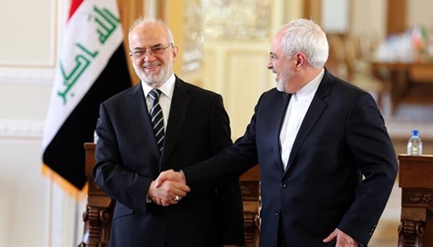 Iraqi Foreign Minister Ibrahim al-Jaafari (left) shakes hands with his Iranian counterpart Mohammad Javad Zarif after a press conference in Tehran on Wednesday.
