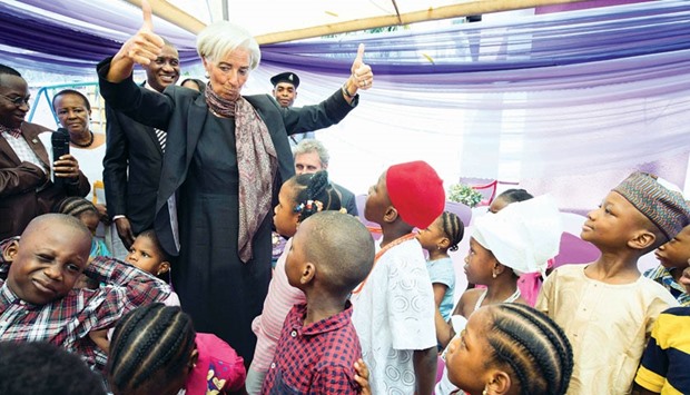 International Monetary Fund managing director Christine Lagarde gives children two thumbs-up after visiting the Mother Theresa Orphanage in Gwarimpa district of Abuja.