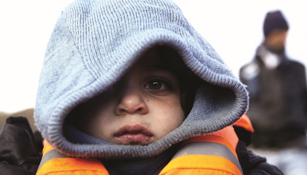 A Syrian child is seen wearing a lifejacket, moments after arriving on Monday on a raft with other migrants on a beach on the Greek island of Lesbos.