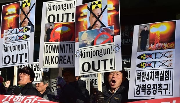 South Korean conservative activists shout slogans with placards showing portraits of North Korean leader Kim Jong Un during a rally denouncing North Korea's hydrogen bomb test, in Seoul on Thursday.