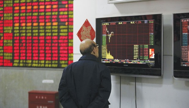 An investor looks at a screen showing stock information at a brokerage house in Shanghai. The Shanghai composite closed up 2.0% at 3,186.41 points yesterday.