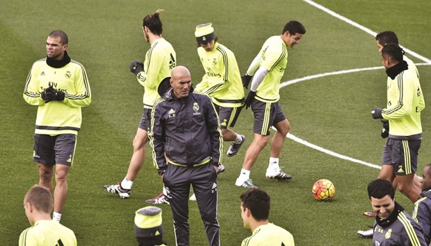Real Madridu2019s new French coach Zinedine Zidane (C) looks at his players during a training session at the Valdebebas training ground in Madrid.