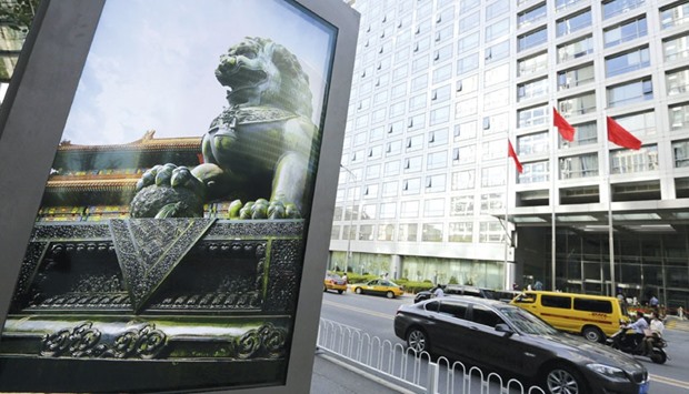 An advertising board (left) showing a Chinese stone lion is pictured near an entrance to the headquarters (right) of China Securities Regulatory Commission in Beijing. Starting today, major investors are permitted to sell no more than 1% of a companyu2019s shares on the open market in three months, the CSRC said.