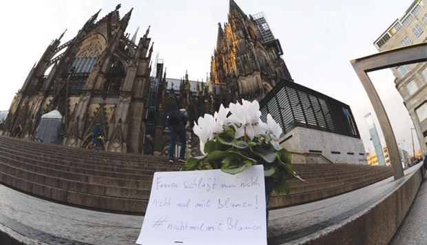 Flowers and a note reading u2018One doesnu2019t beat women u2013 not even with flowersu2019 are laid down in front of Cologneu2019s landmark, the Cologne Cathedral, near the main railway station.
