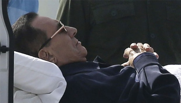 Former Egyptian President Hosni Mubarak lies on a stretcher while being transported ahead of his trial in Cairo, on September 27, 2014.