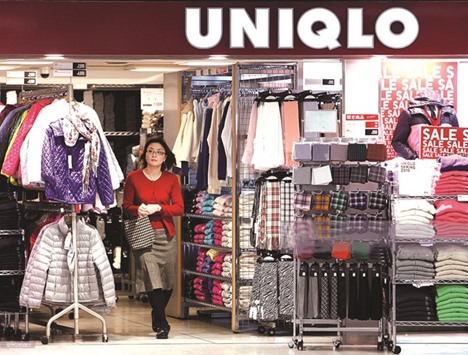 A customer exits Fast Retailingu2019s Uniqlo store in Tokyo. Asiau2019s biggest clothing retailer cut its net income forecast to u00a5110bn, compared with the companyu2019s projection of u00a5115bn made in October.