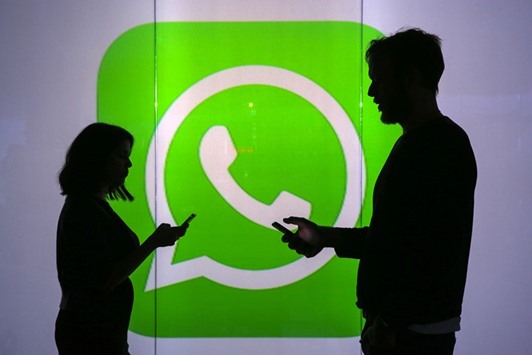 People are seen as silhouettes as they check mobile devices whilst standing against an illuminated wall bearing the WhatsApp logo in London. Under a new proposal presented by the European Union yesterday, web players such as WhatsApp, iMessage and Gmail will have to guarantee the confidentiality of their customersu2019 conversations and ask for their consent before tracking them online to serve them personalised ads.