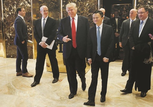 US President-elect Donald Trump walks from an elevator with Alibaba executive chairman Jack Ma after their meeting at Trump Tower in New York on Monday.