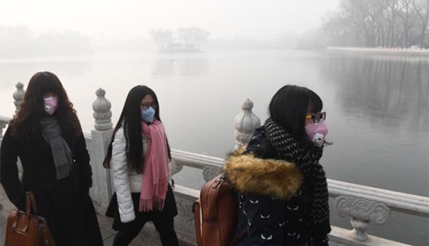 Chinese women wear masks on a heavily polluted day in Beijing on Sunday.