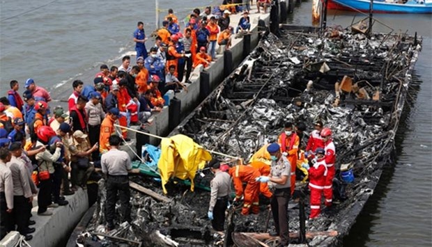 Police and rescue workers search a boat for victims at Muara Angke port in Jakarta on Sunday.