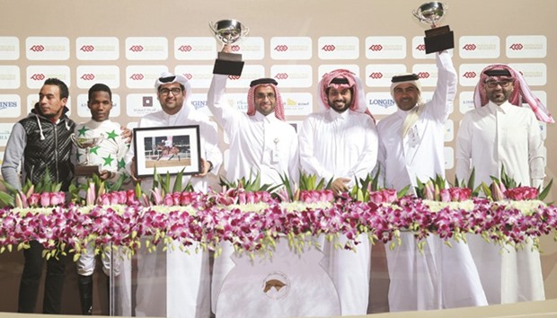 Qatar Racing and Equestrian Club (QREC) general manager Nasser Sherida al-Kaabi (third from right) with the winners of the Umm Taqa Cup after Mowhoubat Al Zaidy won the 1700m race at the QREC yesterday. PICTURES: Juhaim