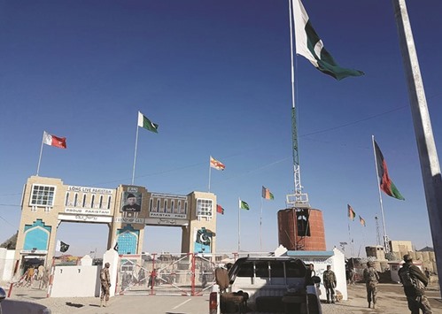 Pakistan security personnel look on as travellers wait to cross the border between Pakistan and Afghanistan at Chaman.