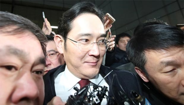 Samsung Electronics vice chairman Jay Y. Lee is surrounded by media as he leaves the office of the independent counsel in Seoul on Friday.