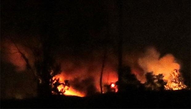 Flames and smoke are seen at the Mezzah military airport on the outskirts of Damascus following an explosion early on Friday.