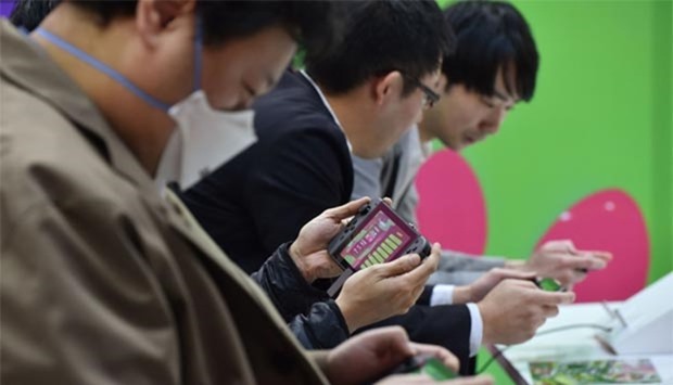 Visitors play Nintendo's new video game console Switch during its presentation in Tokyo on Friday.