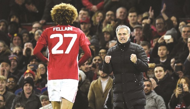 Manchester Unitedu2019s Belgian midfielder Marouane Fellaini (L) celebrates scoring his teamu2019s second goal with Manchester Unitedu2019s Portuguese manager Jose Mourinho during their EFL (English Football League) Cup semi-final football match on January 10.