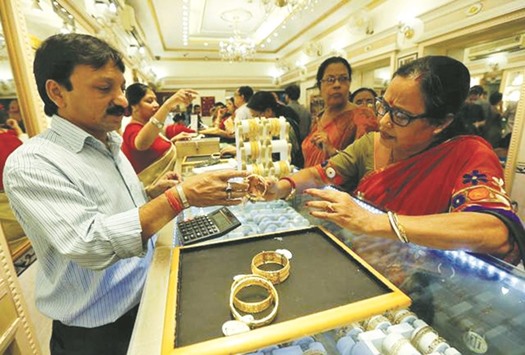 Customers at a gold jewellery shop in Mumbai. Gold-backed exchange traded funds made gold accessible to millions of investors, primarily in the West, over the past decade, but other markets continue to expand too, a World Gold Council report said yesterday.