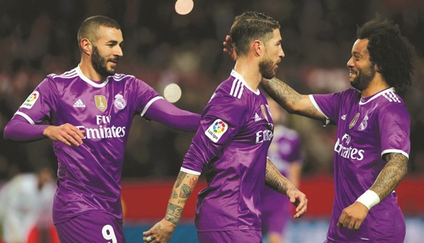 Real Madridu2019s Sergio Ramos (centre) is congratulated by teammates Karim Benzema (left) and Marcelo after scoring a goal against Sevilla during their Copa del Rey match in Seville, Spain, on Thursday. (Reuters)