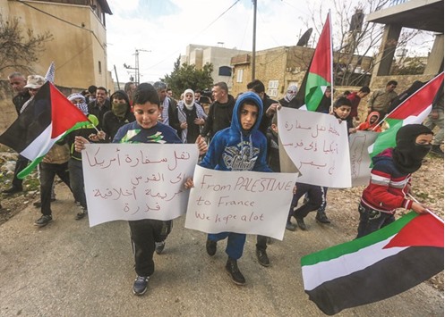 Palestinian children carry placards during a demonstration against proposed plans by President-elect Donald Trump to move the US embassy in Israel to Jerusalem, in the village of Kfar Qaddum, near Nablus, in the occupied West Bank yesterday.