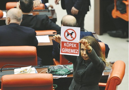This picture taken on Thursday shows AKP lawmaker Gokcen Enc holding up a poster reading u2018Dogs are not allowedu2019, to protest the biting of a colleague during a scuffle at the Turkish parliament.