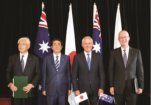 Japanese Prime Minister Shinzo Abe and Australian Prime Minister Malcolm Turnbull stand together with officials Sumio Kusaka (left) and Bruce Miller (right) after a signing ceremony at Kirribilli House in Sydney. Japan and Australia will work together to ensure the Trans-Pacific Partnership free trade deal comes into force, Prime Minister Shinzo Abe said yesterday.