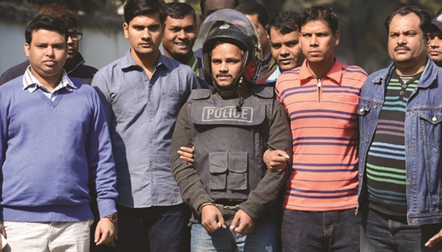 Bangladesh police escort alleged militant Jahangir Alam, centre, in Dhaka yesterday, after his arrest in connection with an attack on the Holey Artisan Bakery attack last year.