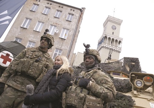 US army soldiers and a local Polish woman pose for a picture after the official welcoming ceremony in Zagan for US troops deployed to Poland as part of the Nato build-up in eastern Europe.