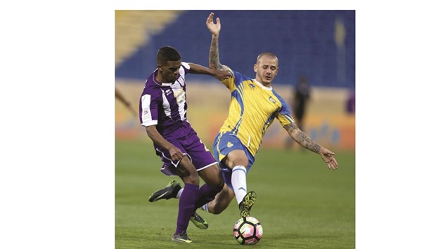 A Muaither and Al Gharafa player vie for the ball yesterday.