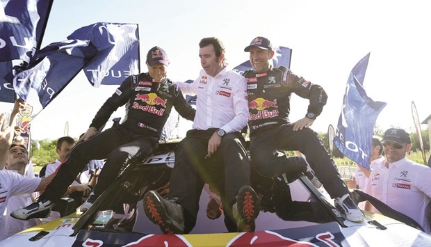 (from L to R) Peugeot co-driver Jean Paul Cottret of France, team manager Bruno Famin and driver Stephane Peterhansel celebrate their victory at the end of the Stage 12 of the Dakar 2017 between Rio Cuarto and Buenos Aires yesterday.