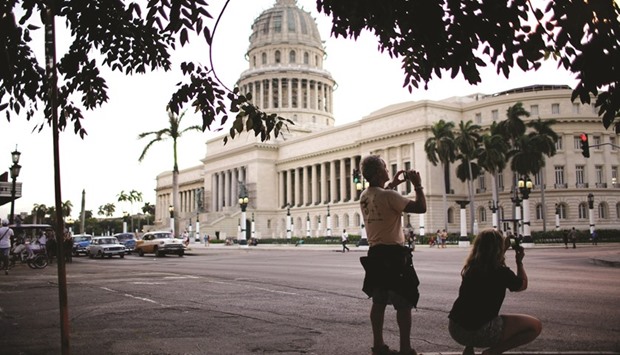 Tourists take pictures near the Capitol Building in Havana.