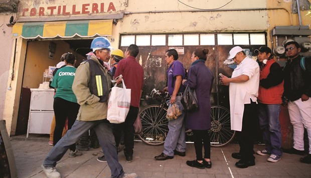 People queue to buy tortillas outside Granada market in Mexico City.