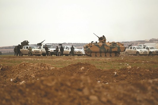 Rebel fighters ride an armoured vehicle on the outskirts of the northern Syrian town of Al-Bab yesterday.