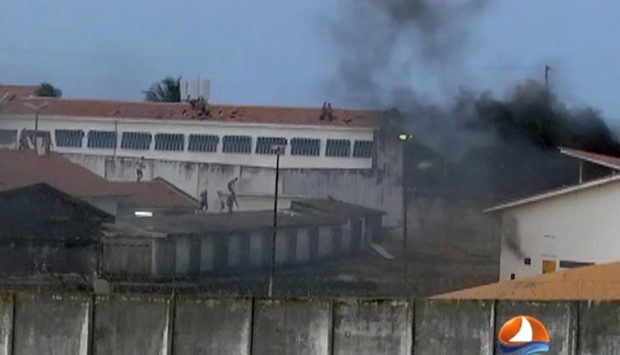 This grab from TV Ponta Negra taken on January 14, 2017 of the Alcacuz Penitentiary Center near Natal, Rio Grande do Norte state, northeastern Brazil shows inmates throwing objects from the prison roof during a riot.