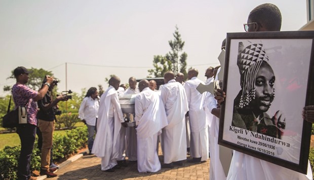 A family member carries a portrait of Rwandau2019s last king, Kigeli V Ndahindurwa, while others carry his coffin to the Kingu2019s Palace in Nyanza, where the funeral services took place yesterday.
