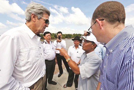 Secretary of State John Kerry (left) talks with Vo Ban Tam (second from right), a former Viet Cong guerrilla who took part in the attack on Kerryu2019s Swift Boat on February 28, 1969, while on a tour of the region in the Mekong River Delta, Vietnam. Kerry once patrolled these waters on a US naval gunboat and received the Silver Star for his actions.
