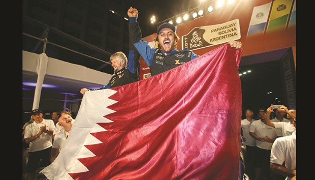 Qataru2019s Mohamed Abu Issa and his co-driver Xavier Panseri celebrate with Qatar flag during their Dakar Rally 2017 campaign.