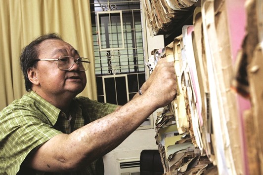 Former newspaper editor Seah Chiang Nee looking through a compilation of his newspaper clippings at his home in Singapore in this 2005 photo. Seah, Southeast Asiau2019s first heart transplant patient and one of the worldu2019s longest surviving cases, has died, his family said yesterday, more than 31 years after his operation.