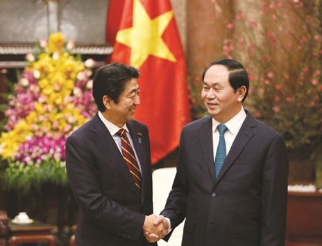 Japanu2019s Prime Minister Shinzo Abe (left) shakes hands with Vietnamu2019s President Tran Dai Quang at the Presidential Palace in Hanoi yesterday.